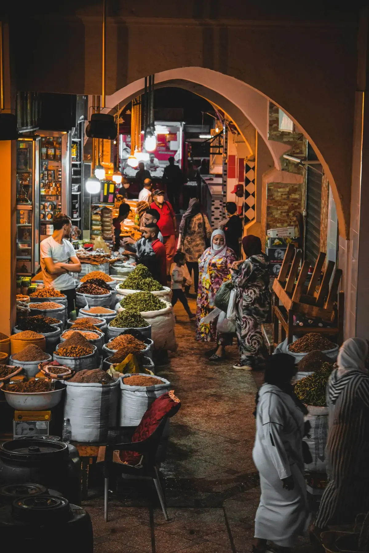 Spice and herb stall lit by warm lamps in a Moroccan market at night