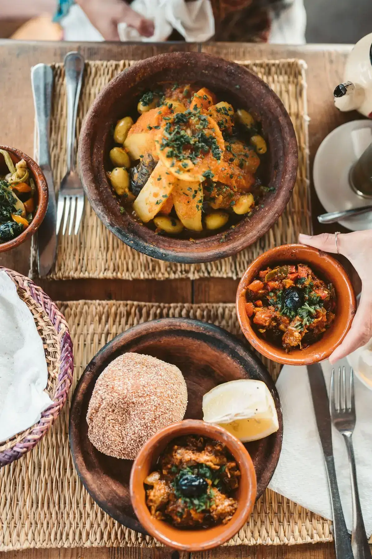 Tagine and cooked salads served in small clay bowls on a Moroccan table