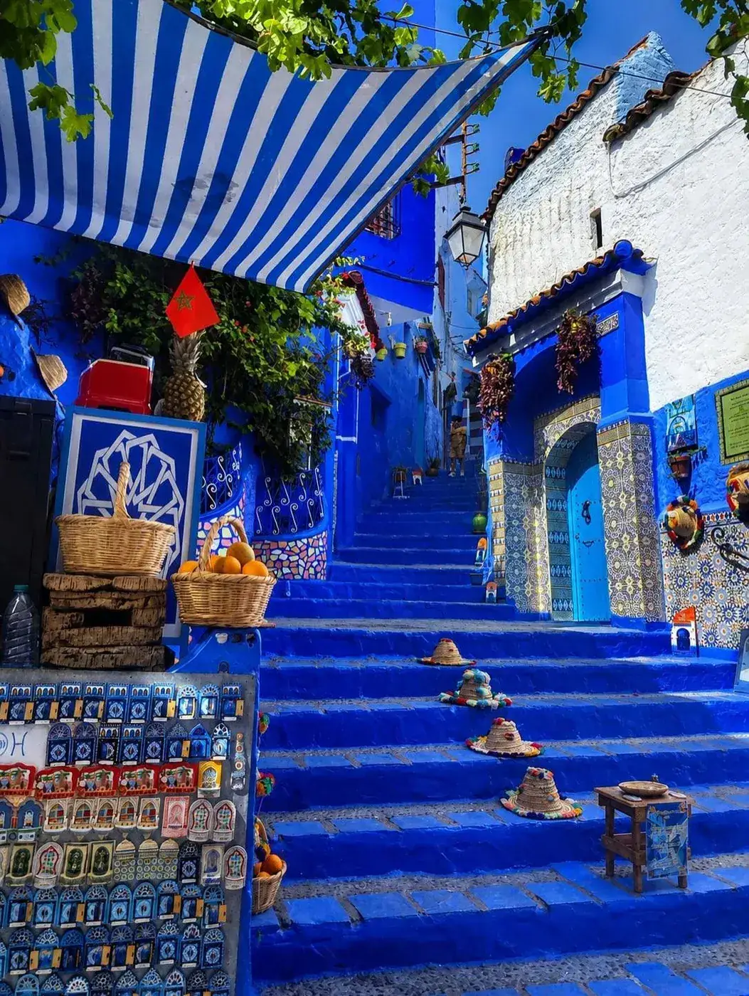 Vibrant blue stairway with small craft shops in Chefchaouen, Morocco