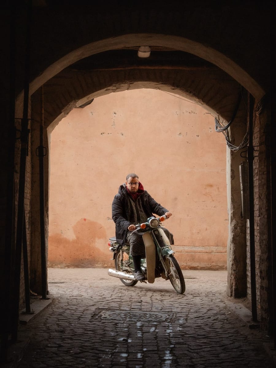 A motorbike passing under an archway in the Marrakech medina