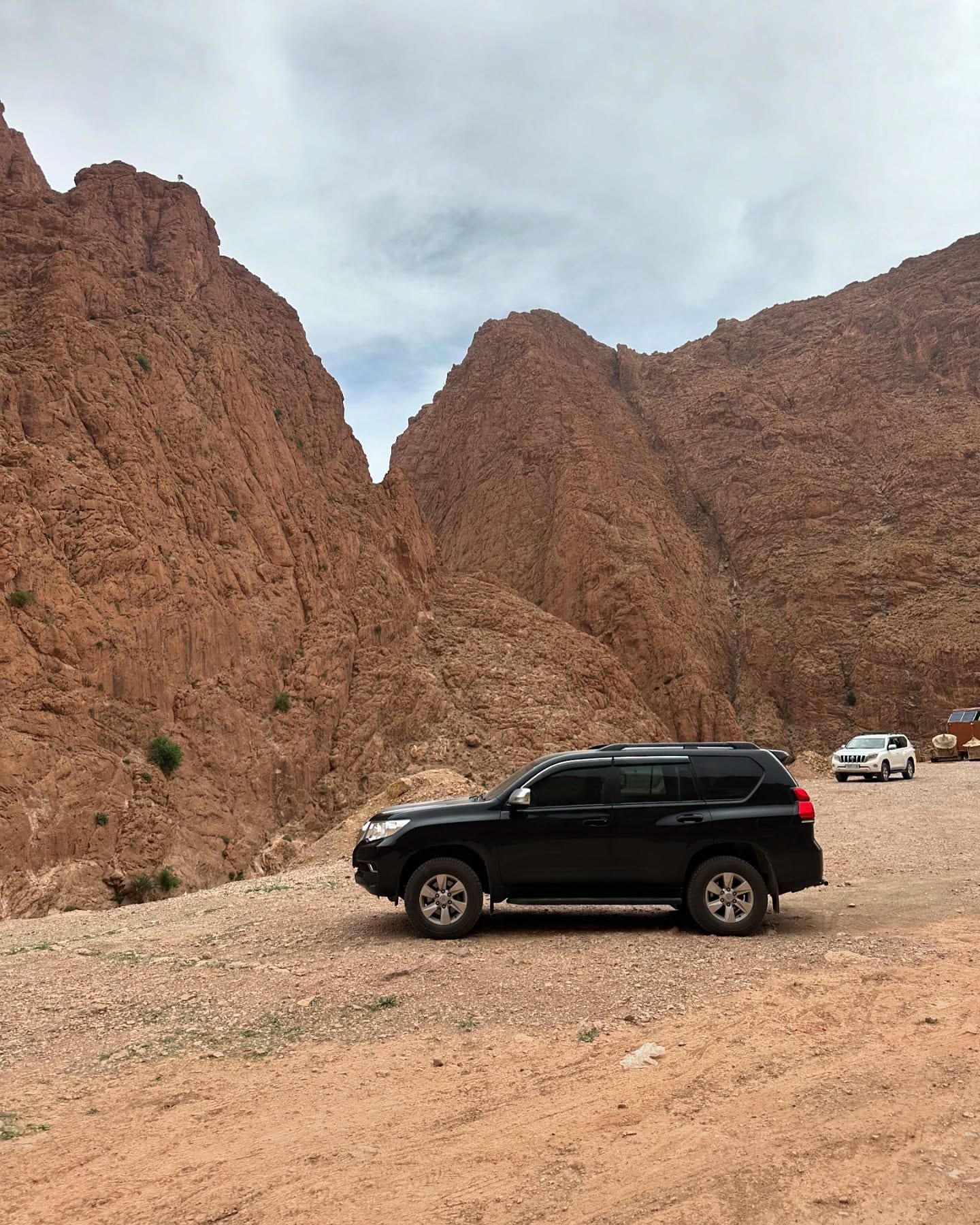 Black Land Cruiser at the entrance of Todra Gorge — private tour fleet at a heritage site