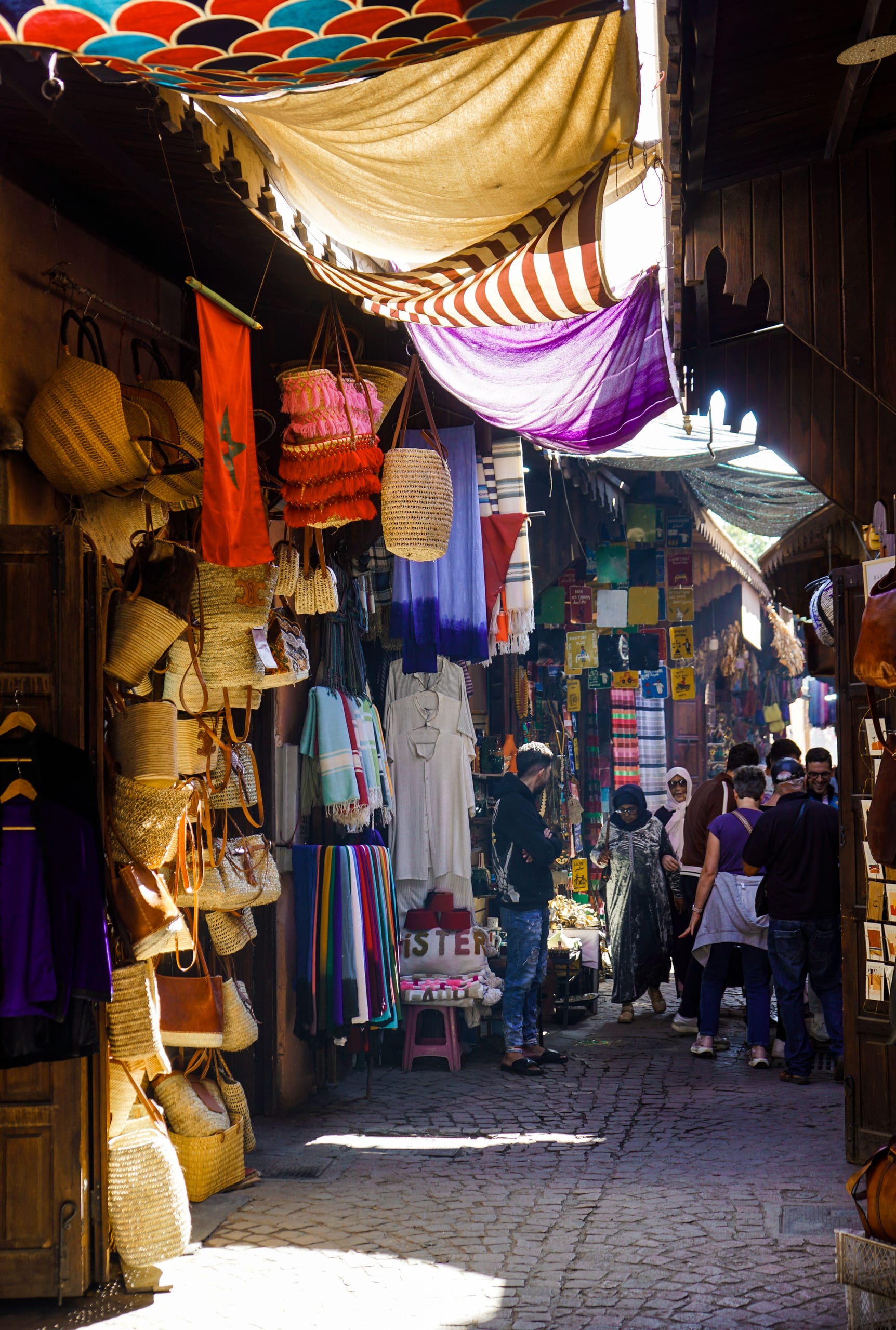 Busy souk alley lined with craft shops in the Fes medina
