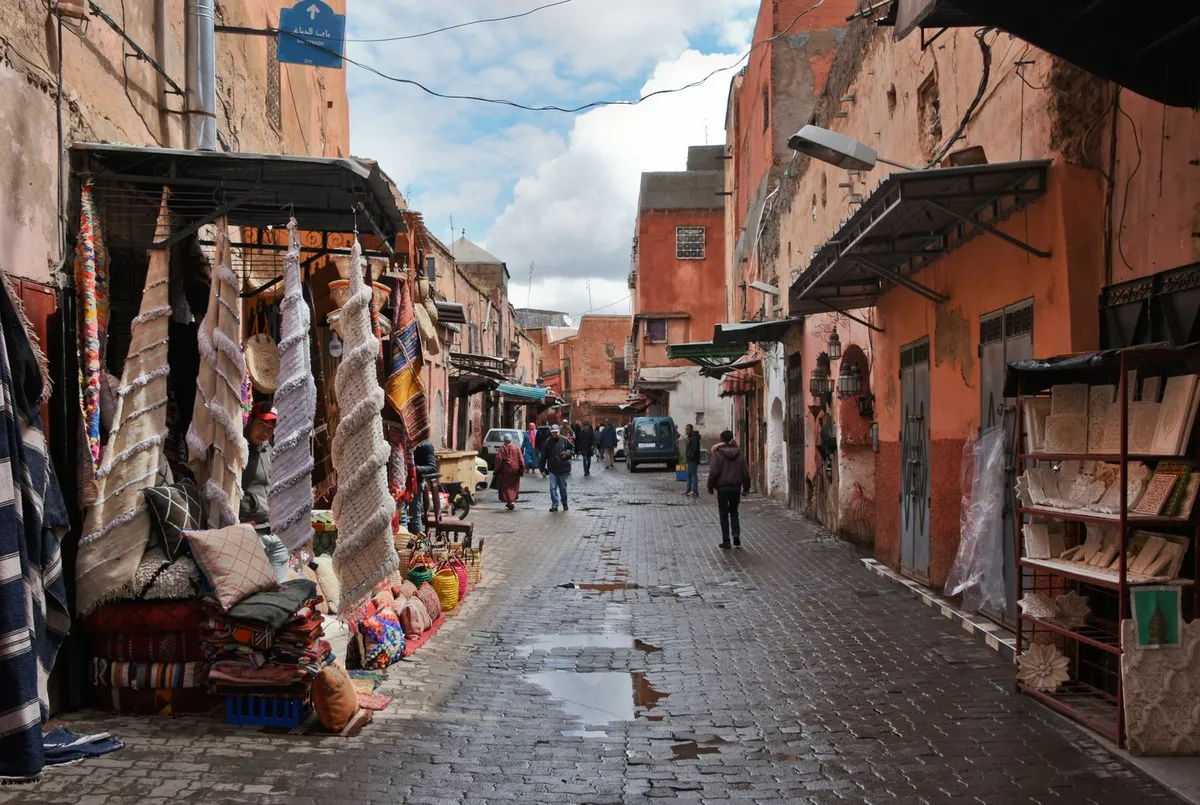 A Marrakech medina alley lined with textiles and handicraft stalls