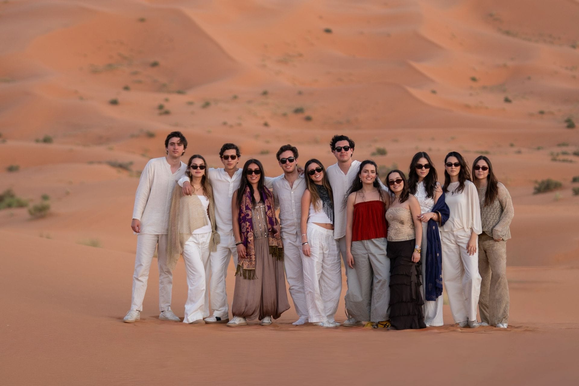 Student group standing together among the Sahara dunes